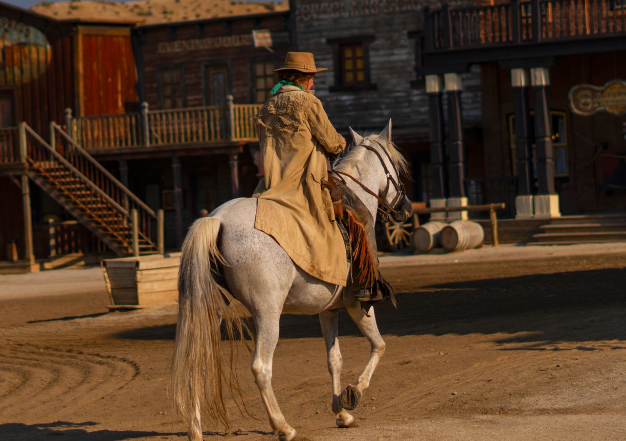 gallery-01 A cowboy rides a white horse in Mini Hollywood theme park, Tabernas, Spain, capturing the essence of the Wild West.