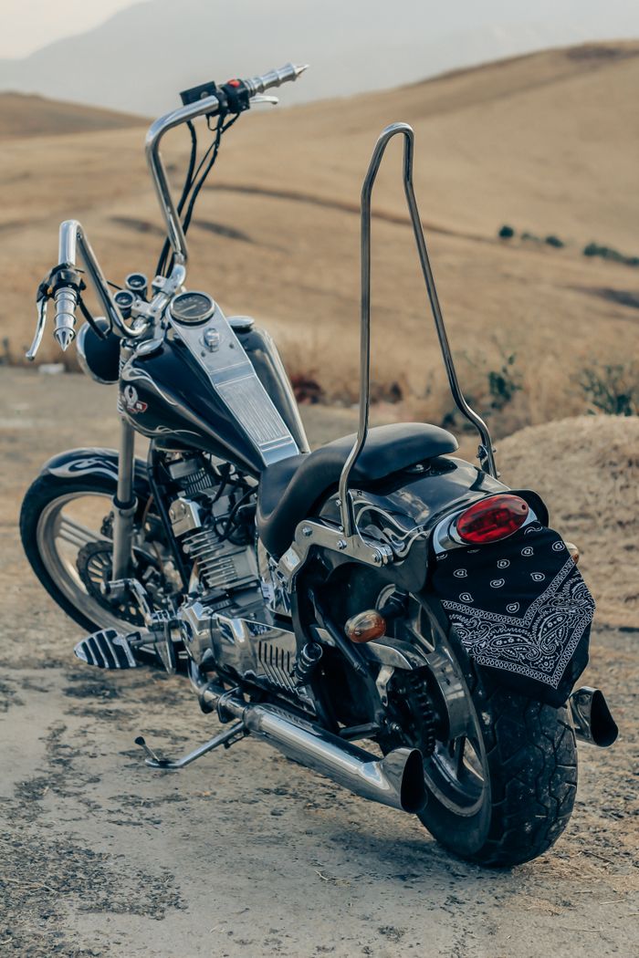 gallery-2 A black motorcycle parked on a dirt road in Urmia, Iran, showcasing vintage design.