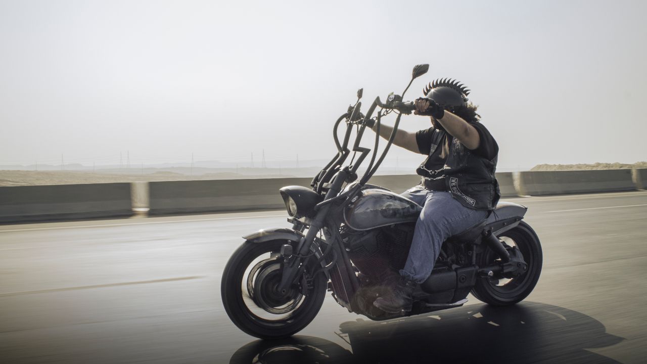 why-choose-us Rider on a custom motorcycle cruising down a highway, showcasing freedom and adventure.